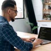 Side view of a programmer with laptop. Clever successful guy, an IT specialist, software developer