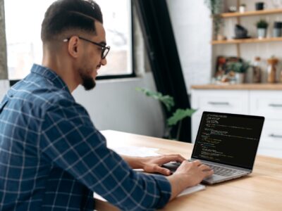 Side view of a programmer with laptop. Clever successful guy, an IT specialist, software developer