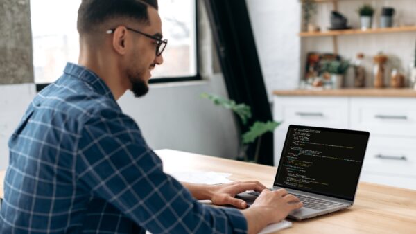 Side view of a programmer with laptop. Clever successful guy, an IT specialist, software developer